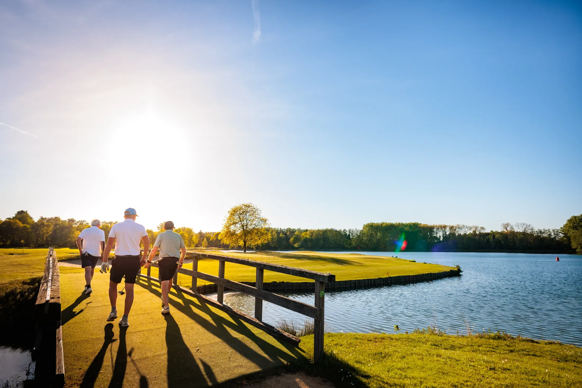 Groep golfers op de brug bij het meer