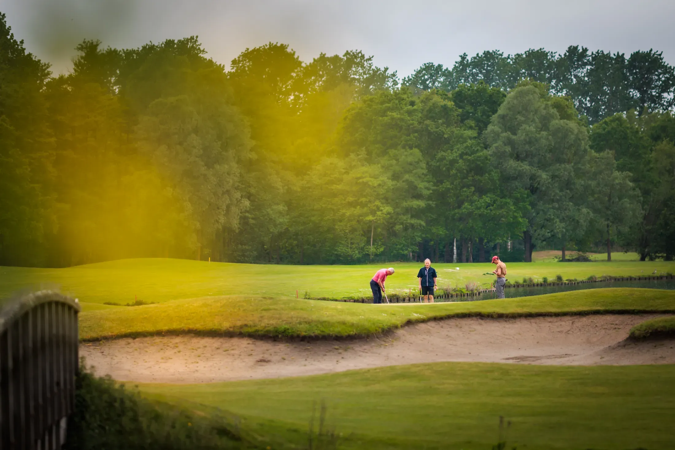 Golfers op de fairway in gouden uurlicht